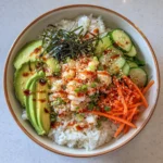 A colorful California roll sushi bowl with crab, avocado, and cucumber.