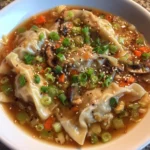 Bowl of steaming gyoza soup with vegetables and broth
